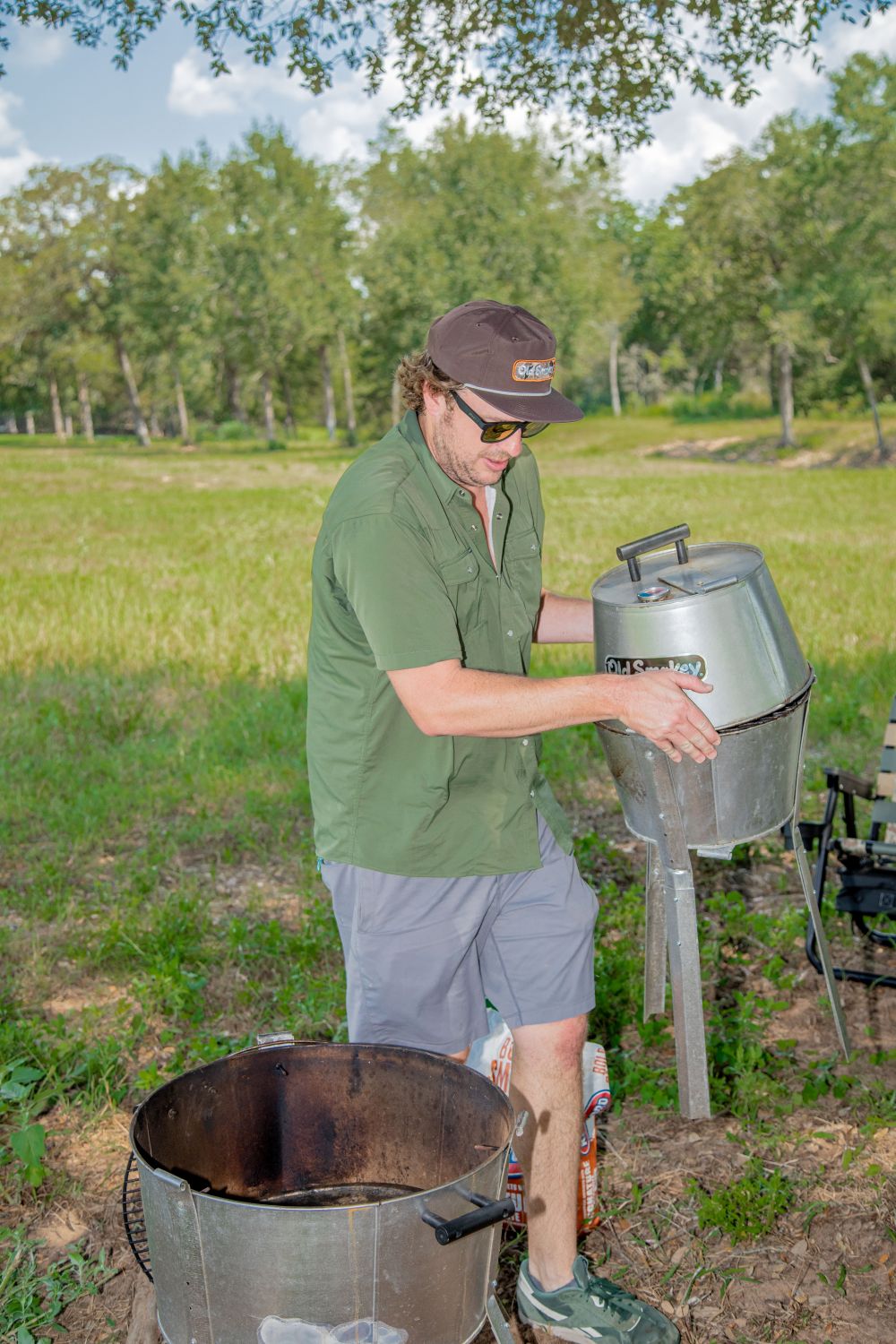 Old Smokey owner John Carter carrying a #14 Old Smokey Charcoal Grill outside